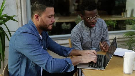 Multiethnic-freelancers-using-laptop-and-discussing-work